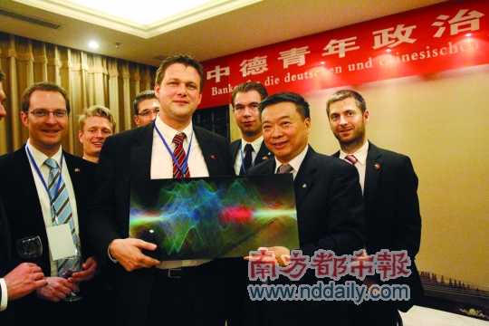 策希(中)與中聯(lián)部副部長李進(jìn)軍交換禮物。 南都記者 吳瑤 攝