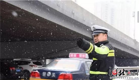 圖為石家莊交警雪中指揮交通。省交管局供圖